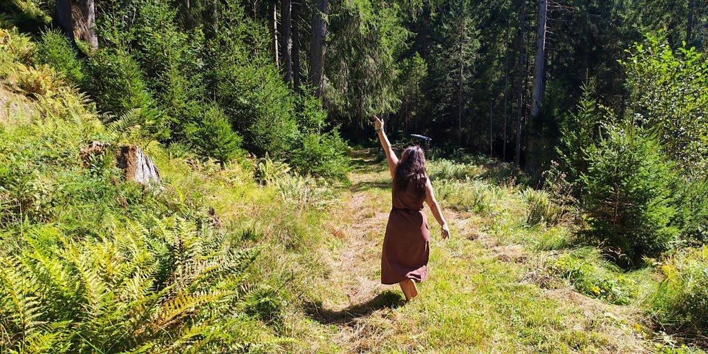 Innere Prozesse - Inneres Kind - Glaubenssätze - Verhaltensmuster Frau tanz fröhlich auf einem Wiesenweg. Sie ist in Verbindung mit ihrem inneren Kind und hat alte Glaubenssätze transformiert